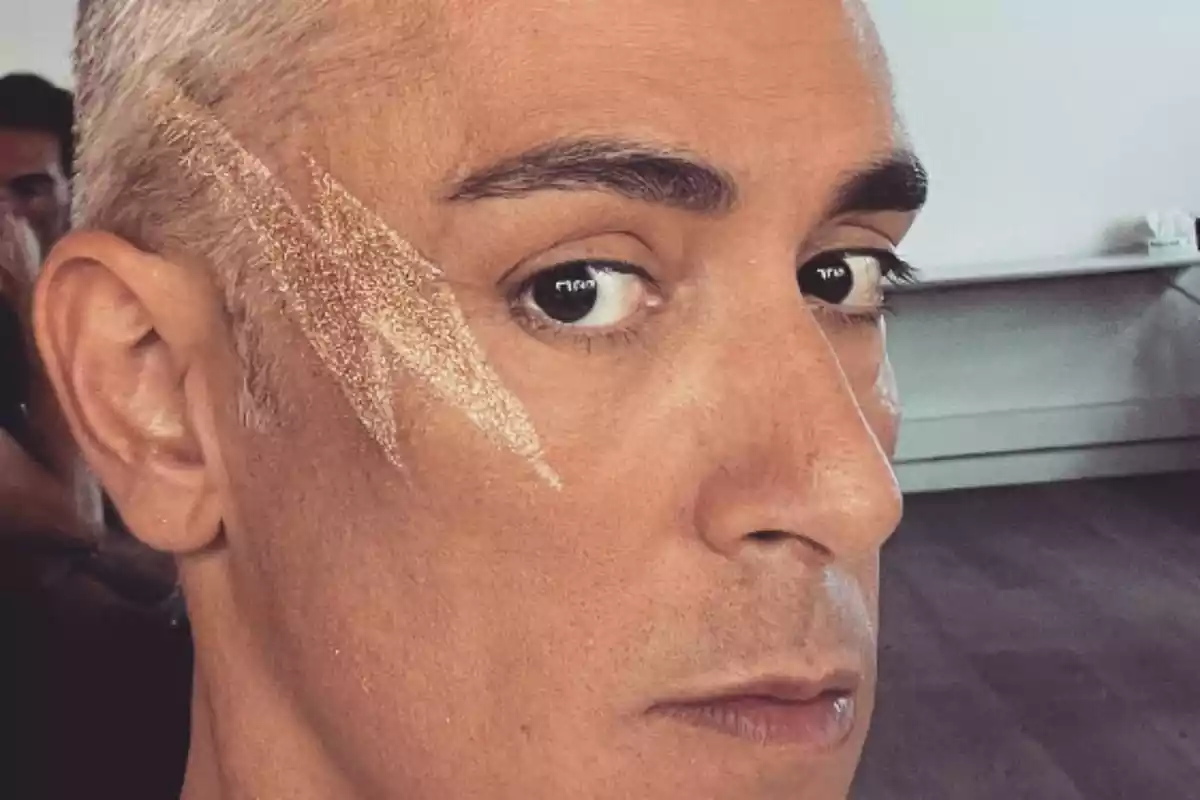 Kiko Hernández con un relámpago de maquillaje en un lado de la cara serio